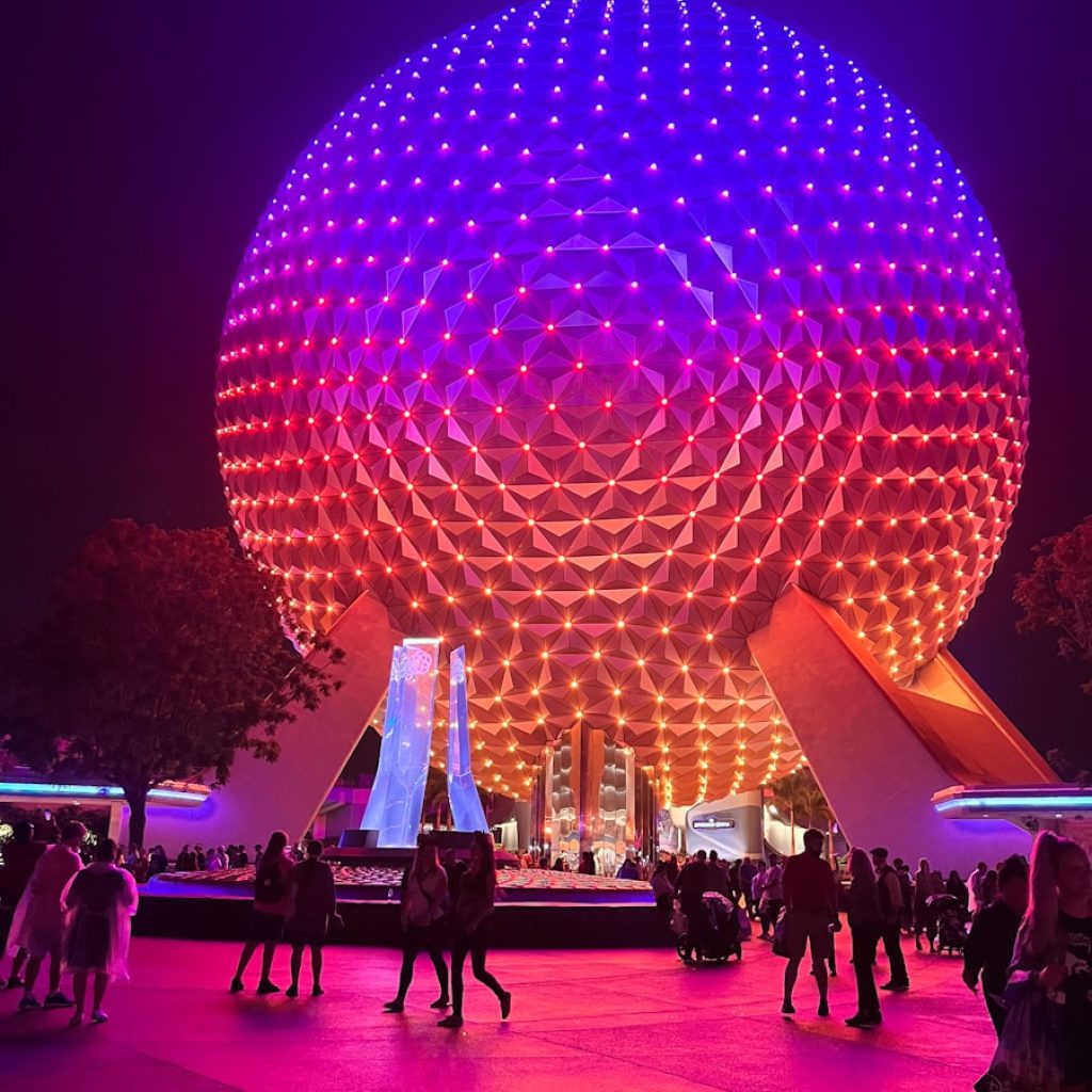 people are walking around in front of a large ball